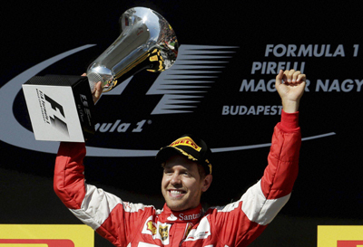 Ferrari driver Sebastian Vettel of Germany celebrates with a trophy after winning the Hungarian Formula One Grand Prix in Budapest, Hungary, Sunday, July 26, 2015.