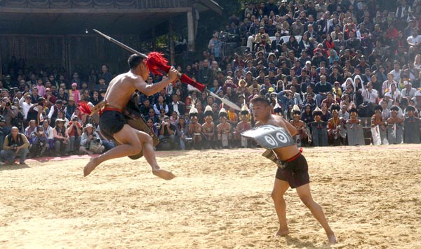 Naga tribesmen depict a battle during the opening day of Nagaland's annual Hornbill Festival. (Photo by Caisii Mao)