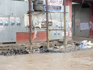 A power conduit stands amid a half-closed but overflowing culvert along Kalibari Road in Dimapur.